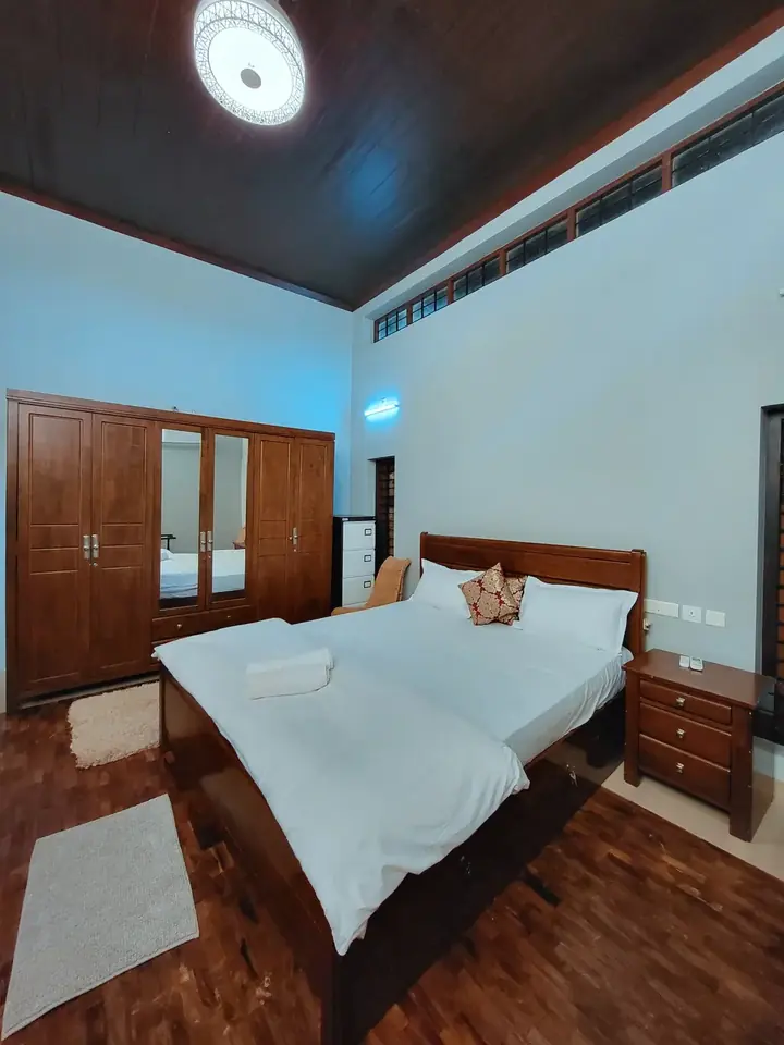 King's Comfort Room at BelleVue with a king-size bed, wooden ceiling and soft lighting