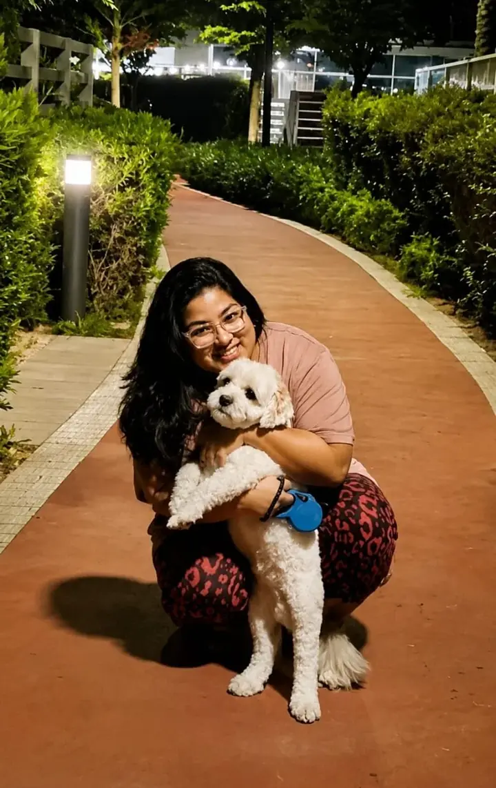 A guest with her dog on the garden path at BelleVue, a pet-friendly stay in Kozhikode