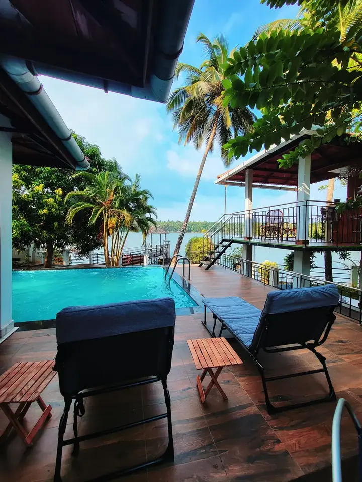 Pool loungers on the deck at BelleVue with the Korapuzha behind